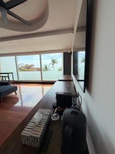 a living room with a table and a couch and windows at Gooseberry Baan & Bistro in Pattaya South