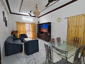 a living room with a glass table and chairs at Elegant 2 BHK Furnished flat without AC and with AC additional price in Belgaum