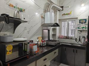 a kitchen with a counter top with a microwave at Elegant 2 BHK Furnished flat without AC and with AC additional price in Belgaum