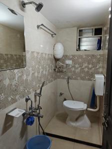 a bathroom with a toilet and a mirror at Elegant 2 BHK Furnished flat without AC and with AC additional price in Belgaum +23 photos