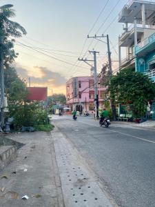 two people riding motorcycles down a city street at Hotel Thúy Hằng Núi Sam Châu Đốc in áº¤p VÄ©nh ÃÃ´ng