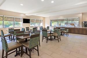 a dining room with tables and chairs and windows at Comfort Suites Columbia Northeast - Fort Jackson in Dentsville