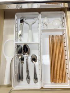 a white tray with silver utensils in a drawer at inn 3rd in Kurashiki