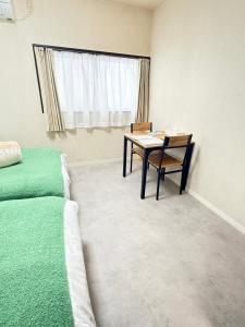 a bedroom with a desk and a bed and a table at inn 3rd in Kurashiki