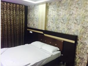a bed in a room with curtains and a bed sidx sidx sidx at Highway Grand Residency in Hyderabad