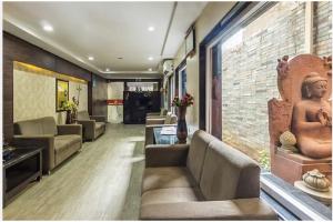 a living room with couches and a wall with a statue at Highway Grand Residency in Hyderabad