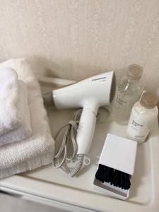 a hair dryer sitting on a shelf next to towels at inn 3rd in Kurashiki