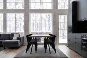 a kitchen and living room with a table and chairs at Villa Taalontuuli Aurora & Forest Views sleeps 10 in Kittilä