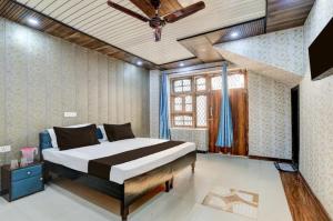 a bedroom with a bed and a ceiling fan at Nice hotel in Faridabad