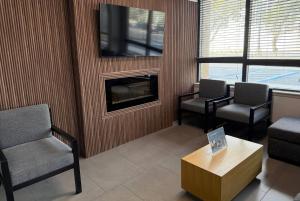 a waiting room with two chairs and a fireplace at Wingate by Wyndham Jacksonville FL in Jacksonville