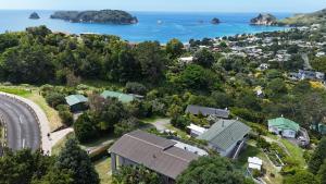 an aerial view of a house and the ocean at Cathedral Cove Retreat in Hahei
