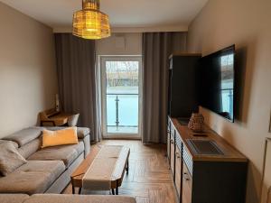 a living room with a couch and a flat screen tv at Apartamenty TBG Tarnobrzeg in Tarnobrzeg