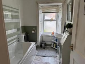 a small bathroom with a tub and a sink at COSY COTTAGE FOR SHARE , Private Double Room, Wifi, Parking, Garden in Edinburgh