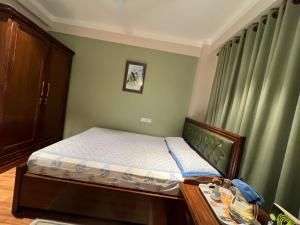 a small bed in a bedroom with green walls at Shivalaya Suites in Pātan