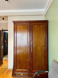 a wooden cabinet in a room with a couch at Shivalaya Suites in Pātan
