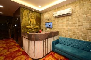 a lobby with a large mural of a buddha on the wall at Hotel Vijay Palace in Agra