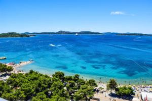 an aerial view of a beach with people in the water at hotel depandance Imperial Green by GLOBTOUR in Vodice
