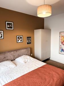 a bedroom with a bed and a wall with pictures at Apartamenty TBG Tarnobrzeg in Tarnobrzeg