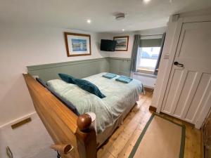 a bedroom with a bed with blue pillows on it at Cosy cottage in Torquay