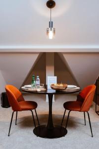 a table with two chairs and a table with food on it at Héritage Collection - Suites in Verviers +23 photos