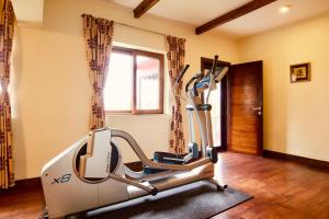 a gym with a treadmill in a room with a window at May Cottage By Rokeby Villas in Mussoorie