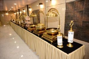 a long table with gold items on top of books at Hotel Vijay Palace in Agra