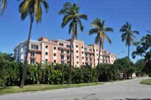 a pink building with palm trees in front of it at Marina Costa Bonita in Mazatlán