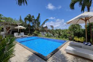 a swimming pool with chairs and an umbrella at Kelingking Point in Nusa Penida