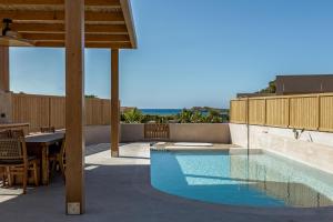 a swimming pool on the patio of a house at Unique Blue! Resort and Villas Adults Only in Karteros