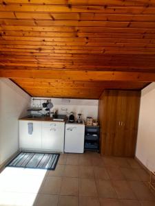 a kitchen with white appliances and a wooden ceiling at Terrazza Belvedere Sanremo in Sanremo +16 photos