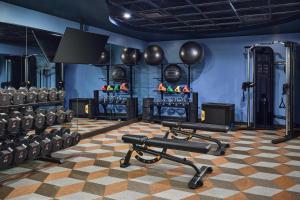 a gym with dumbbells and a group of equipment at the Curtis Denver - A DoubleTree by Hilton Hotel in Denver