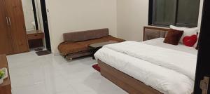 a bedroom with a bed and a chair and a window at Royal Hotel in Begūn