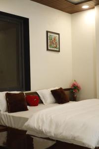 a bedroom with a white bed with pillows on it at Royal Hotel in Begūn +3 photos
