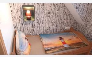 a bedroom with a bed with a picture of a lighthouse at Haus Seemöwe Obergeschoss in Wittmund