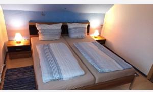 a bedroom with two beds with pillows and two lamps at Haus Seemöwe Obergeschoss in Wittmund