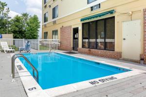 a large blue swimming pool in front of a building at Comfort Suites Dover University Area in Dover