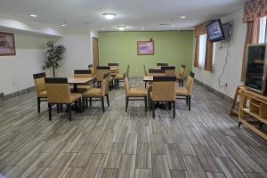 a dining room with tables and chairs and a television at Quality Inn Durand I-69 in Durand