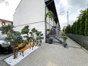 a building with a bench and trees on a sidewalk at Apartamenty TBG Tarnobrzeg in Tarnobrzeg