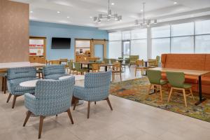 a waiting area with tables and chairs in a waiting room at Hampton Inn Midland West in Midland