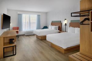 a hotel room with two beds and a flat screen tv at Hampton Inn Midland West in Midland +25 photos