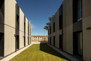 an alley between two buildings with grass between them at Kronoguest - Auto check-in in Castañares