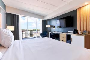 a hotel room with a large white bed and a desk at Radisson Hotel Paramaribo in Paramaribo