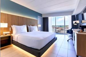 a hotel room with a large bed and a balcony at Radisson Hotel Paramaribo in Paramaribo