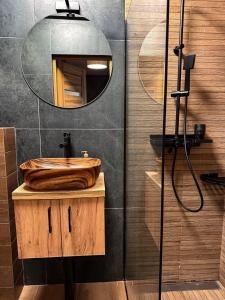 a bathroom with a wooden sink and a mirror at Apartamenty TBG Tarnobrzeg in Tarnobrzeg +34 photos