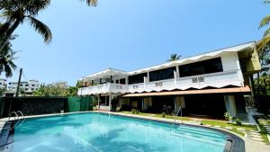 a swimming pool in front of a building at Oliviana Resort in Bentota