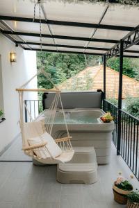 a porch with a hammock and a hot tub at Wonder Bűbáj Mátrafüred in Gyöngyös