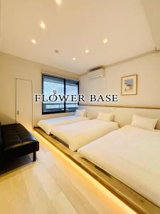 two beds in a room with a sign that reads flowerbase at Flower Base HIMAWARI in Fukuoka