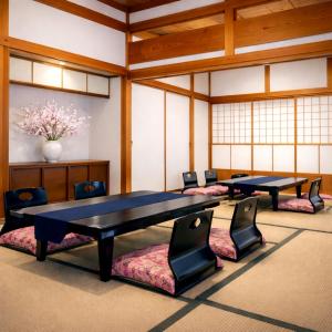 two tables and chairs in a room with windows at 里や 糸島 川遊び Bbq 花火を楽しむ古民家1棟貸し in Itoshima