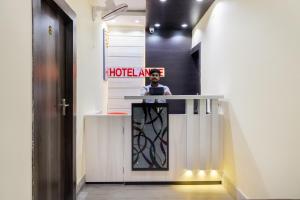 a man standing at a reception desk in a hallway at Hotel O Annie in Rāmgarh