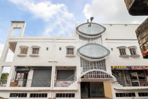 a white building with round windows and balconies at Hotel O Annie in Rāmgarh